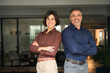 © insta_photos - Portrait of happy executive managers, two business man and woman leaders entrepreneurs, corporate partners business owners professional work team standing arms crossed in office looking at camera.