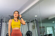 © CandyRetriever  - Wellness Health Technology. Healthy Asian woman do sport training fitness workout exercise at gym. Sporty girl in sportswear using smartwatch health app and listening to music on earphones at stadium.