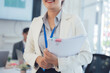 © Kritdanai - Confident Businesswoman Holding Documents in Office