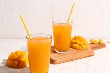 Wall Mural - Glasses of fresh mango smoothie on light background