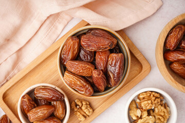 Wall Mural - Bowls with dried dates and nuts on light background
