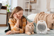 © Pixel-Shot - Young woman with plaid and Maine Coon cat lying near electric fan heater in bedroom