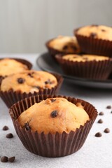 Wall Mural - delicious muffin with chocolate chips on light grey table, closeup