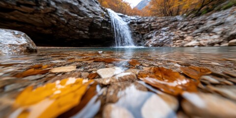 Leinwandbilder - Scenic waterfall cascading into a tranquil pool surrounded by rocks and vibrant autumn foliage creating a serene natural landscape