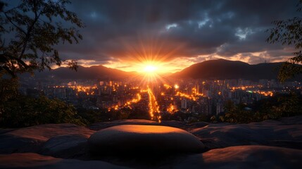 Poster - Sunset Over Cityscape Behind Mountain Range with Golden Orange Light in Cloudy Twilight