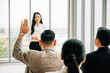 © sorapop - Active engagement is on display as a large group in a seminar classroom raises their hands to participate in the discussion. The answers lie within this dynamic conference audience.