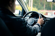 © terovesalainen - Driver in rideshare car or taxi. Test drive or training. Used vehicle insurance. Delivery man or ride share business. Illegal cab. Behind view.