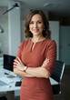 © ProArt Studios - Chic mid-40s businesswoman in stylish attire, looking at the camera with a satisfied expression setting.