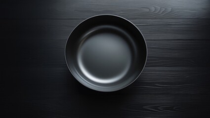 Poster - On a dark hardwood surface, a top view of a round empty black bowl.