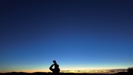 Wall Mural - silhouette of a man with binoculars and countryside under the stars and moonlight.