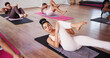 © peopleimages.com - Stretching, women and group in studio, exercise or yoga with balance, workout or health benefits. Support, breath or people in wellness center, calm or stress relief with fitness, flexible or hobby