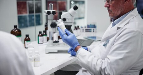 Poster - Scientist, man and label on bottle in laboratory for drugs research, production and development. Medical, science and mature doctor with medicine for pharma, biology innovation and sticker on cure