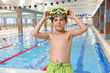 © New Africa - Cute boy in trunks with diving mask at indoor swimming pool