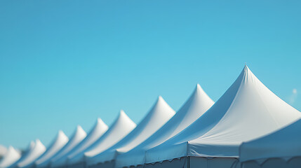 Poster - Row of white tent tops under a blue sky background