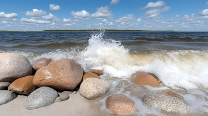 Wall Mural - waves crashing against smooth, colorful rocks on a sandy beach under a bright, sunny sky