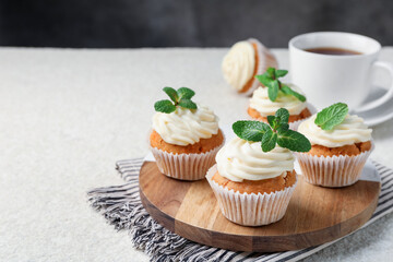 Wall Mural - delicious carrot cupcakes with mint on light textured table, closeup. space for text