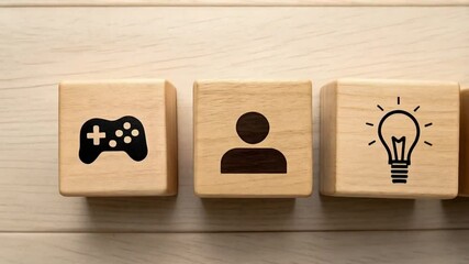 Poster - Hand arranging wooden blocks with game controller, person, light bulb and gears icons on a wood surface
