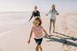© Marko Geber - Multigenerational family having fun and walking on a sandy beach together