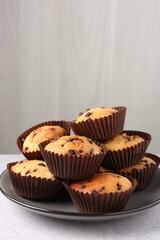 Wall Mural - delicious muffin with chocolate chips on light grey table, closeup
