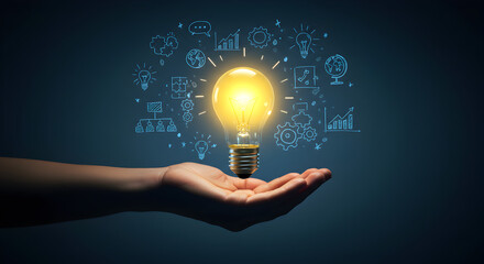 Poster - Hand Holding a Glowing Light Bulb with Business Icons on Dark Blue Background Illustrating Creative Business Idea