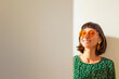 © zhukovvvlad - Woman face. Portrait of gorgeous girl with beautiful earrings and orange sunglasses, smiling at camera, looking confident and cheerful.