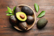 © New Africa - Fresh ripe avocados and leaves on wooden table, flat lay