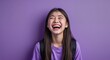 © sevenSkies - Caucasian teen girl on purple plain bright background happy laughing hysterical looking at camera portrait banner with copy space ad concept marketing