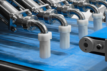 Aufkleber - Blue conveyor belt with series of white plastic tubes for production of candies and cakes.