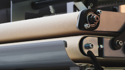 Poster - A machine with a belt made of a material that is not visible. The belt is attached to a metal machine