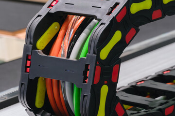 Poster - A black and yellow cable organizer with a red stripe. The cable organizer is made of plastic and has a yellow and red stripe