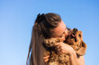 © Alina - Cocker spaniel shares a loving moment with woman owner against a clear blue sky