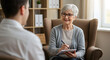 © abu - Senior Woman in Gray Cardigan Conducting Therapy Session with Man in Light Filled Office