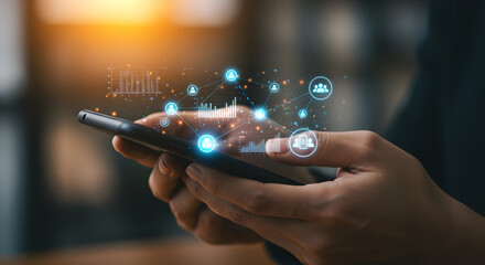Poster - Person Holding Smartphone Displaying Digital Data Visualization with Blurred Background and Warm Lighting