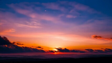 Wall Mural - Fiery Sunset Silhouette: The sky ablaze with fiery hues as the sun dips below the horizon, painting the clouds with vibrant colors and casting a mesmerizing silhouette.
