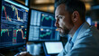 © Pug - A stock trader monitors market fluctuations on multiple screens in a financial office.