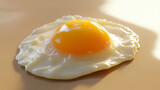 Fried egg with runny yolk placed on a soft neutral b