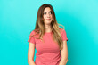 © luismolinero - Young caucasian woman isolated on blue background making doubts gesture looking side
