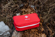 © Aleksey - A red first aid kit is sitting on a log in the woods