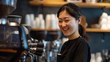 Cheerful Asian barista making coffee using the machine in a coffee shop.