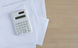 © chinnarach - close up top view on calculator and open over calculator and group of invoice letter mail and from bank on wood table background for money and debt management concept