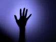 © Magdalena - Black Hand Behind The Glass, Backlit By A Dim Light. Blurry Silhouette of Black Hand on a Dark Violet Background. Nightmare Or Horror Movie Scene with Hand Touching Glass Door.