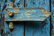 © Wiryo - Weathered blue arrow-shaped wooden latch on a rustic door.