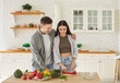 © Studio Romantic - Healthy happy couple enjoy cooking salad in modern kitchen for slimming vegetarian diet, eating green raw vegetables, veggies dinner at home, progress in weight loss, husband helping wife making food
