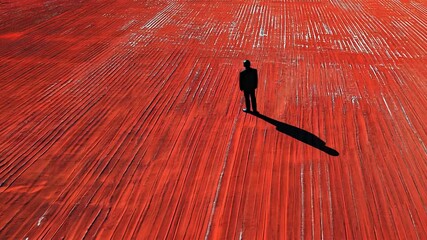 Poster - Construction Worker Stands on Vibrant Red Surface at Job Site Generative AI