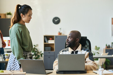 Aufkleber - Young serious male employee looking at female colleague during discussion of details of developing new software