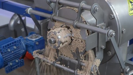 Aufkleber - Machine is pouring sand into a container. The sand is coming out of the machine in a steady stream