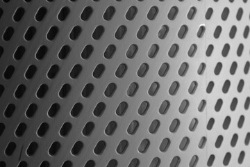 Wall Mural - textured metal surface featuring circular perforations with varying sizes and shadows creating a mod