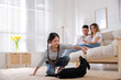 © New Africa - Little girl playing with puppy while parents sitting on sofa in living room