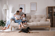 © New Africa - Happy family on sofa and puppy in living room