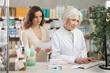 © JackF - Mature woman pharmacist at computer communicate with female client. Employee answers visitors questions, interprets doctors prescription, selects available drugs for treatment regimen